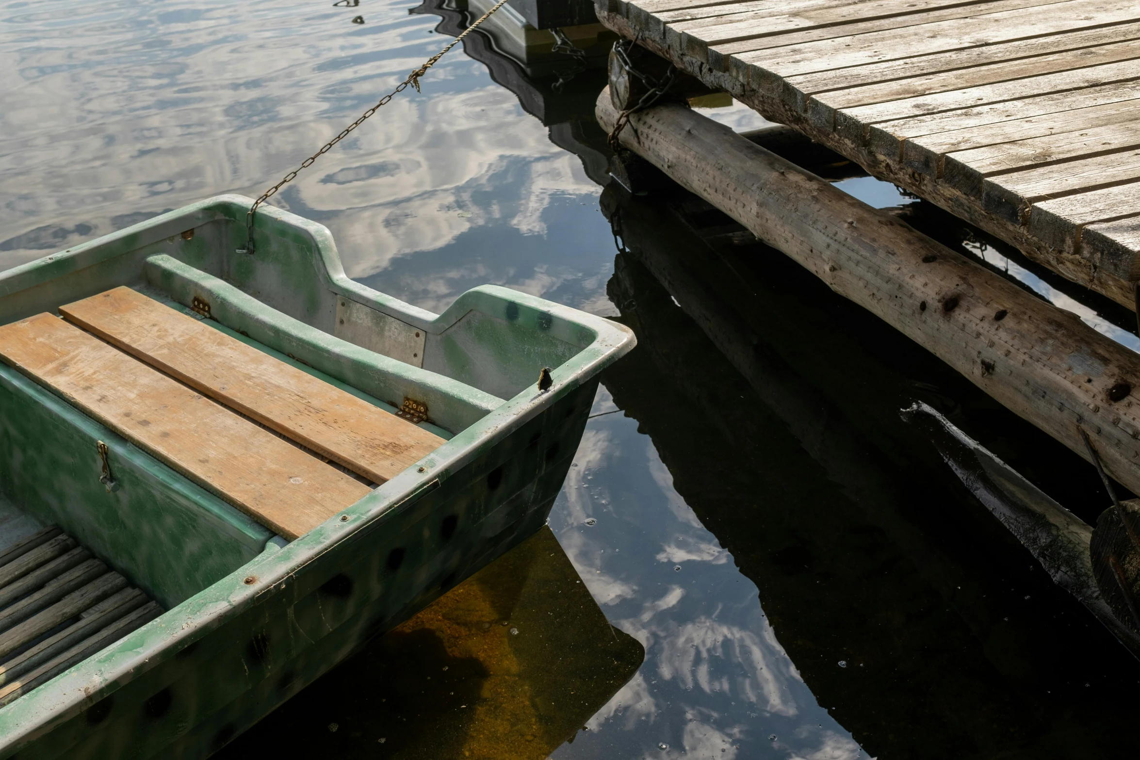 a green boat sitting on top of a lake next to a dock, by Elsa Bleda, pexels contest winner, photorealism, grey, dingy, thumbnail, a wooden