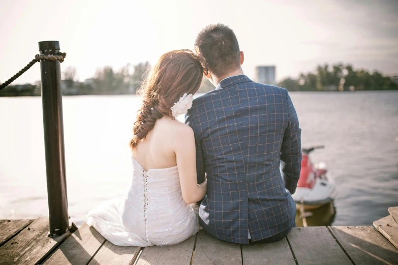 a man and a woman sitting on a dock, pexels, romanticism, wearing a wedding dress, cuddly, over his shoulder, hoang lap
