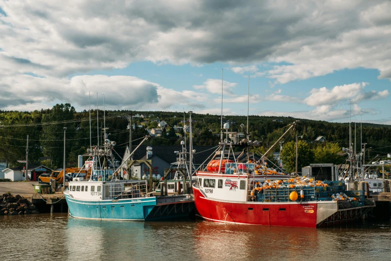 a couple of boats that are sitting in the water, by Jessie Algie, pexels contest winner, fish seafood markets, quebec, conde nast traveler photo, three - quarter view