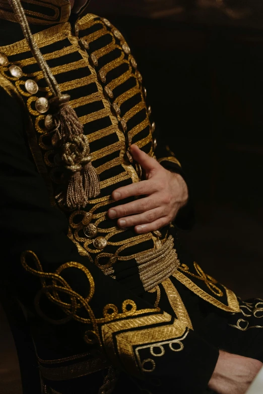 a man in a military uniform posing for a picture, an album cover, inspired by Jean-François de Troy, trending on pexels, baroque, golden thread, side view intricate details, hands crossed, theatrical