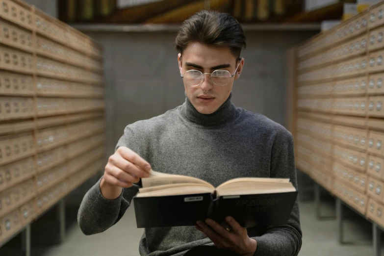 a man reading a book in a library, a portrait, pexels contest winner, square rimmed glasses, thin young male alchemist, gif, lachlan bailey