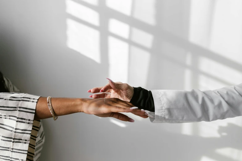 two people shaking hands in front of a window, by Emma Andijewska, visual art, white backdrop, wearing lab coat and a blouse, a high angle shot, healing