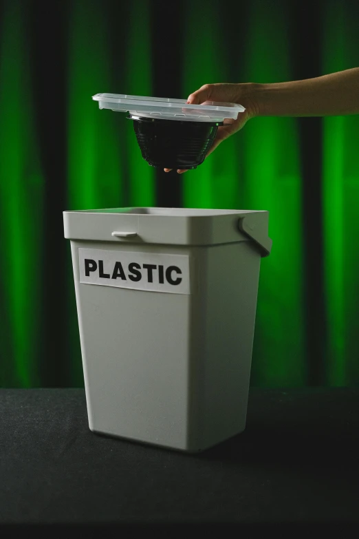 a person putting a plastic container into a trash can, inspired by Elsa Bleda, plasticien, paul barson, practical effects, green, contest winner 2021