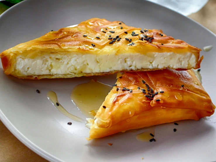 a close up of a plate of food on a table, inspired by Géza Dósa, hurufiyya, melted cheese, pastry, greek, hasselblatt