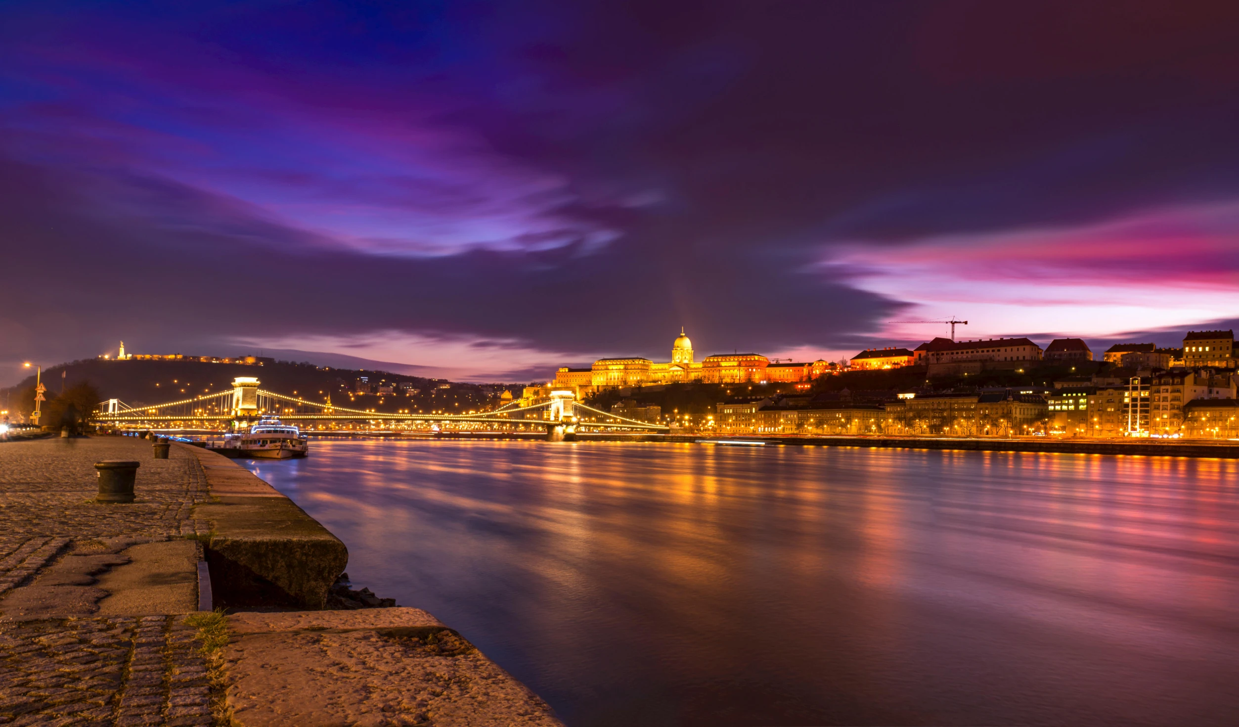 a bridge over a river with a castle in the background, by Adam Szentpétery, pexels contest winner, orange and purple electricity, budapest, panoramic, slide show