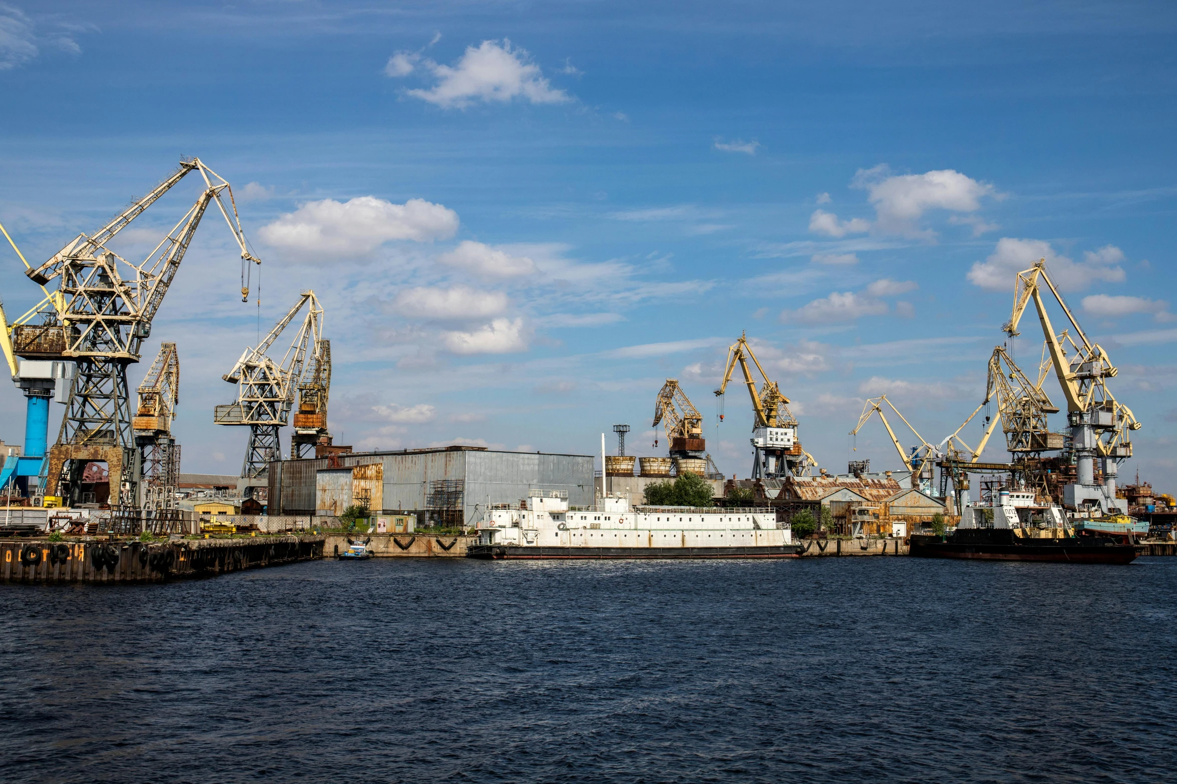 a large body of water with lots of cranes in the background, pexels contest winner, figuration libre, soviet yard, hull, sunny environment, high quality product image”