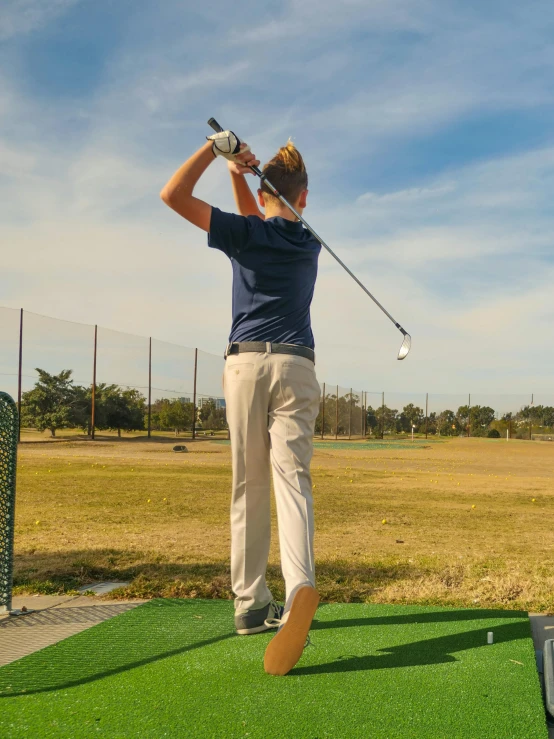 a woman swinging a golf club at a golf course, inspired by Sven Nordqvist, standing on 2 feet, lachlan bailey, origin jumpworks, back facing