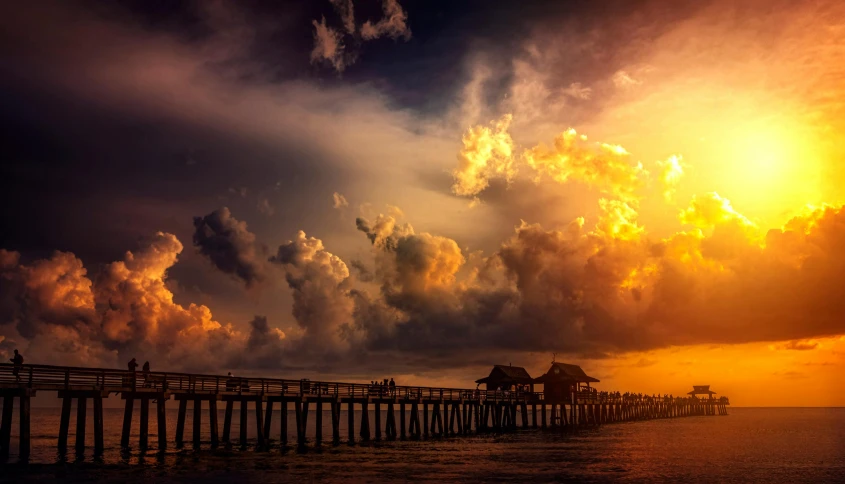 a pier in the middle of the ocean under a cloudy sky, pexels contest winner, romanticism, sun set, instagram post, “puffy cloudscape, a colorful