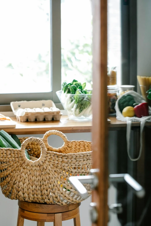 a wicker basket sitting on top of a wooden stool, getting groceries, bright window lit kitchen, profile image, various items