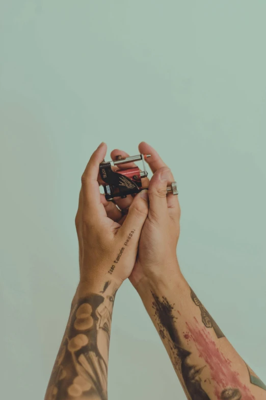 a man with tattoos on his arms holding a rub rub rub rub rub rub rub rub rub rub rub rub rub rub rub rub rub rub rub, a tattoo, inspired by Elsa Bleda, unsplash, holding polaroid camera, holding each other, shot from above, vintage colors