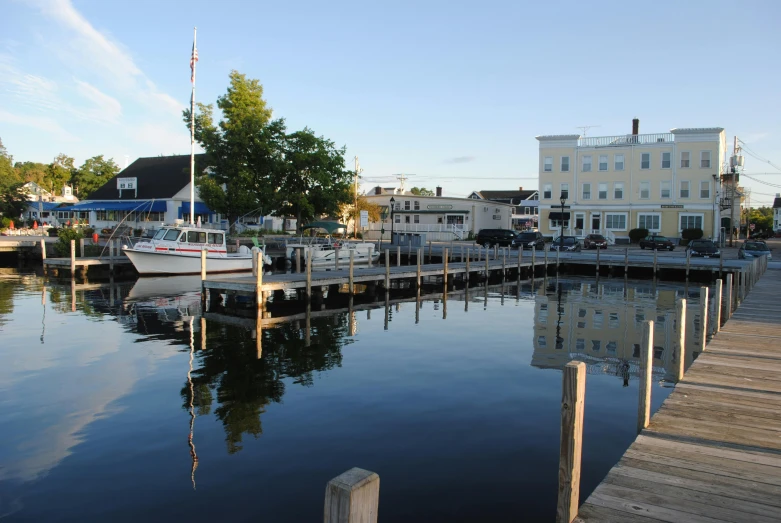 a wooden dock next to a body of water, whitewashed buildings, craigville, multiple stories, thumbnail