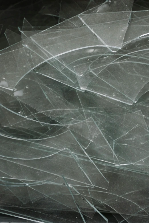 a bunch of broken glass sitting on top of a table, many smooth curves, spidery irregular shapes, surface blemishes, up-close