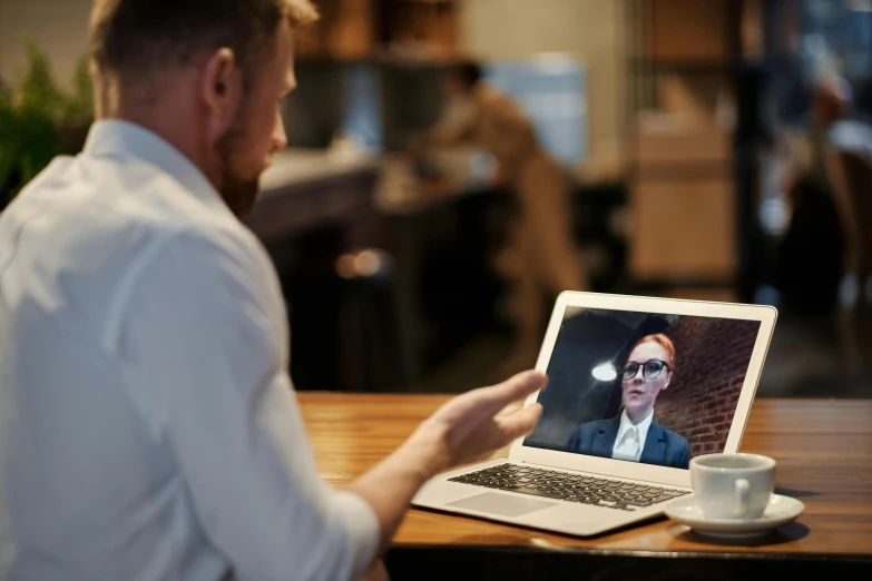 a man sitting at a table using a laptop computer, a portrait, trending on pexels, video art, wearing a suit and glasses, hr ginger, in meeting together, lachlan bailey