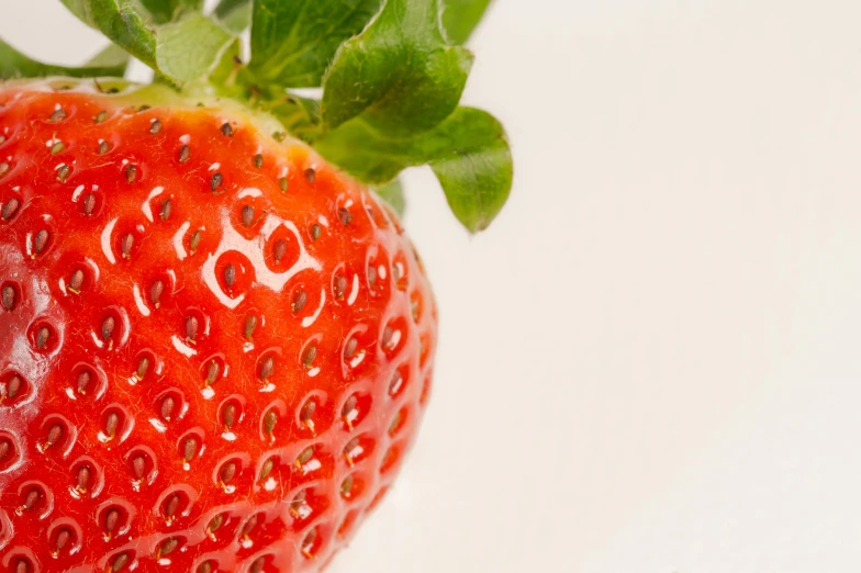 a close up of a strawberry on a white surface, by Adam Marczyński, pexels, detailed product image, high details photo, image, high resolution image