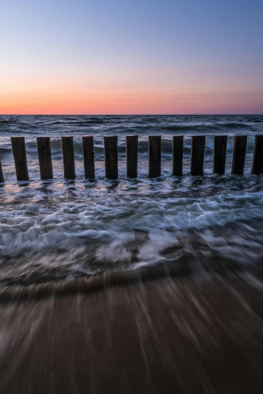 a large body of water next to a beach, by Daniel Seghers, pillars, break of dawn on neptun, fence line, 15081959 21121991 01012000 4k