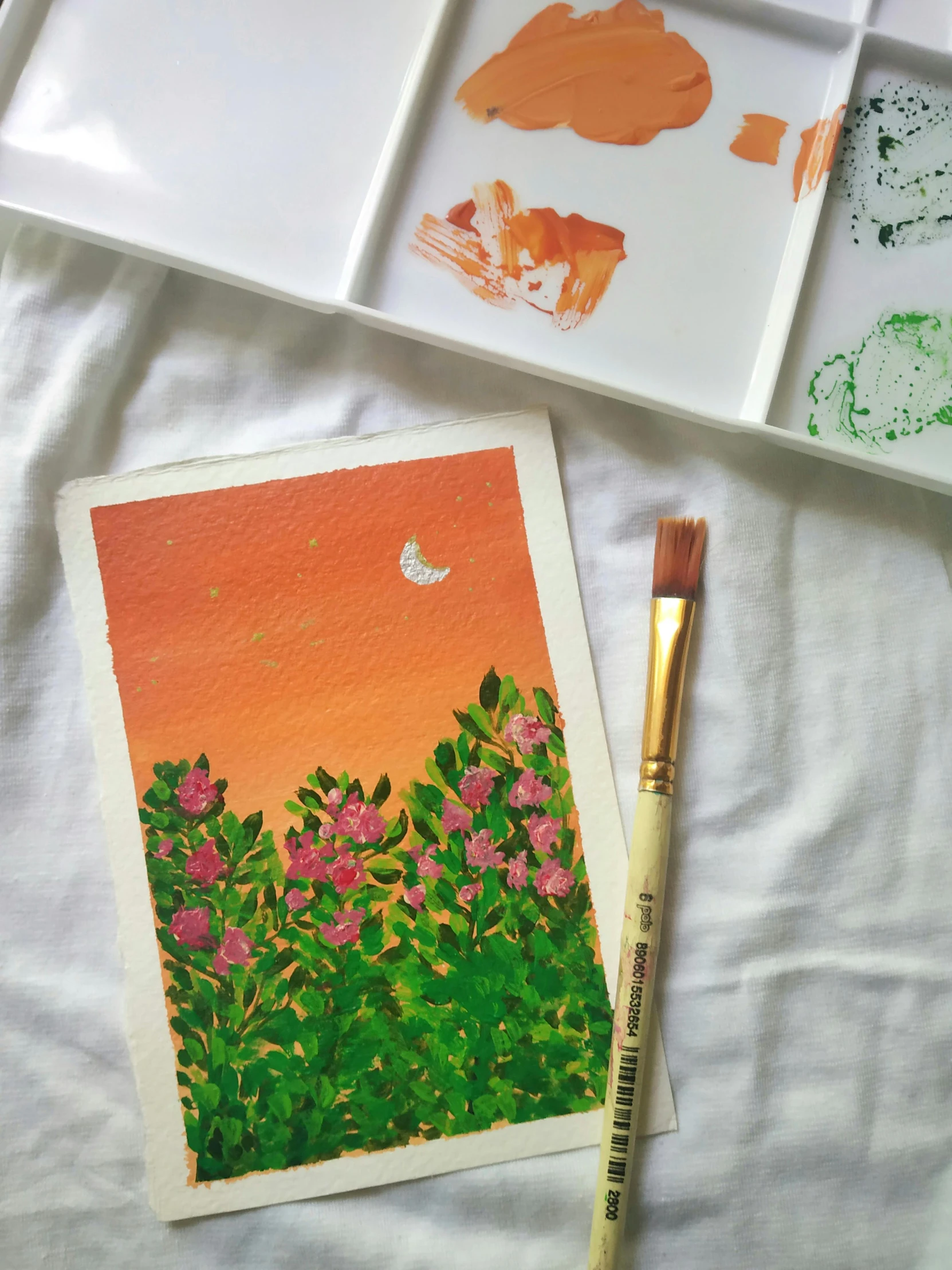 a painting sitting on top of a table next to a brush, an acrylic painting, inspired by Kim Du-ryang, green and orange theme, flatlay, orange / pink sky, delicate garden on paper