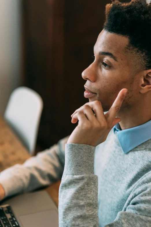 a young man sitting in front of a laptop computer, trending on pexels, renaissance, looking to the right, black man, androgynous male, high quality screenshot