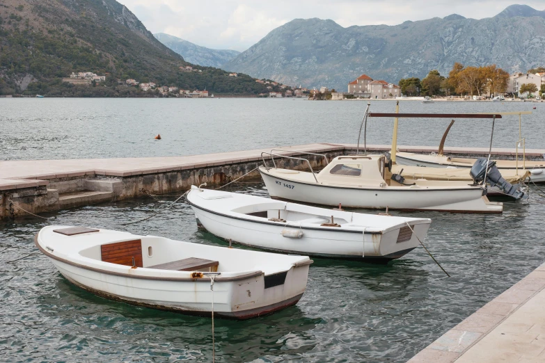 a number of small boats in a body of water, by Joanna Carrington, trending on unsplash, boka, small port village, grey, conde nast traveler photo