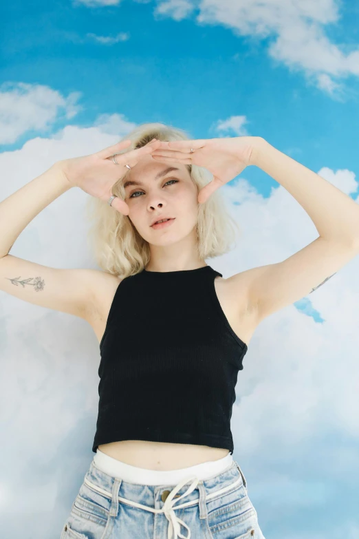 a woman standing in front of a cloudy sky, an album cover, inspired by Elsa Bleda, trending on pexels, wearing a cropped black tank top, pale fair skin!!, pose model, arms out