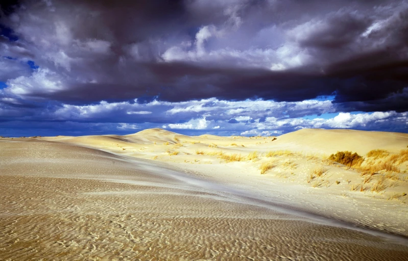 a person riding a surfboard on top of a sandy beach, stormclouds, the australian desert, slide show, craters