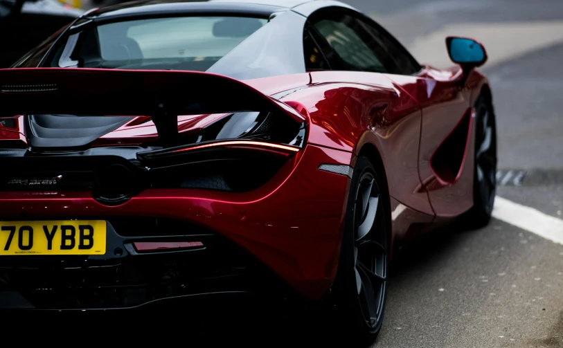 a red sports car parked on the side of the road, inspired by Harry Haenigsen, pexels contest winner, precisionism, mclaren, back, maroon red, thumbnail