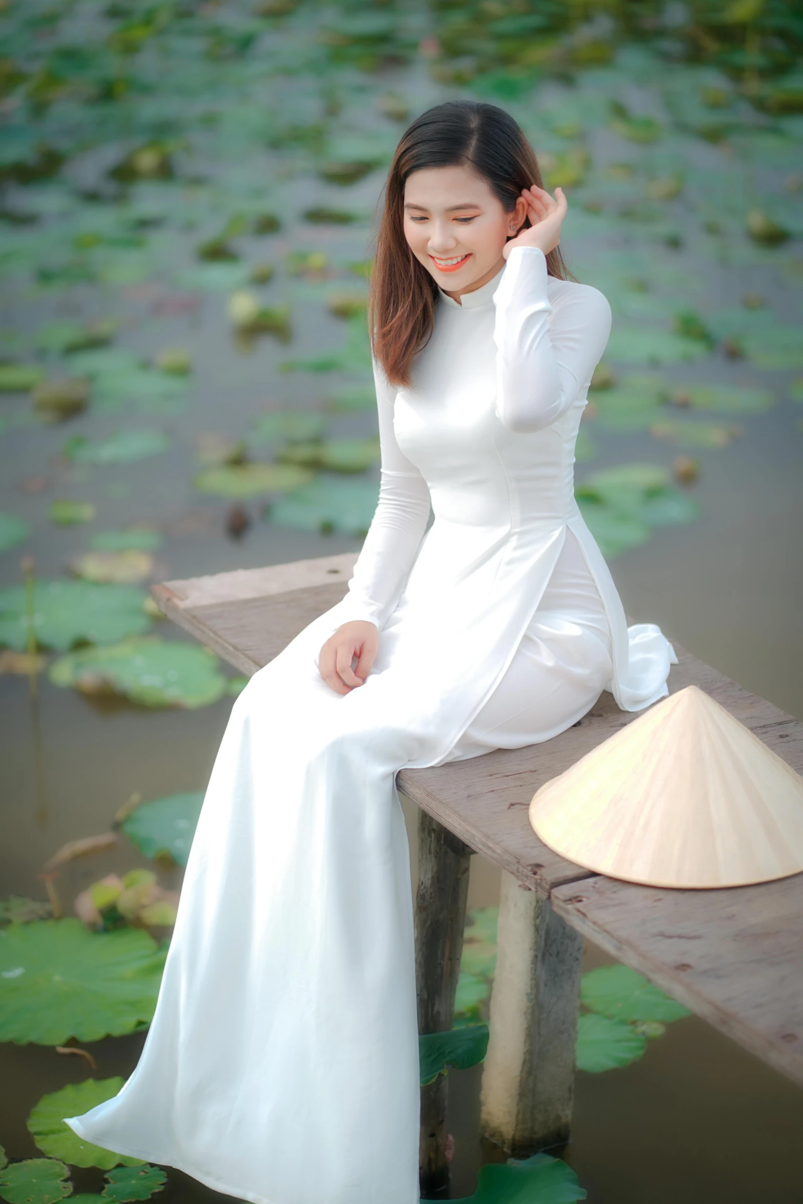 a woman in a white dress sitting on a wooden bench, inspired by Tan Ting-pho, pexels contest winner, happening, ao dai, standing on a lotus, white clothing, square