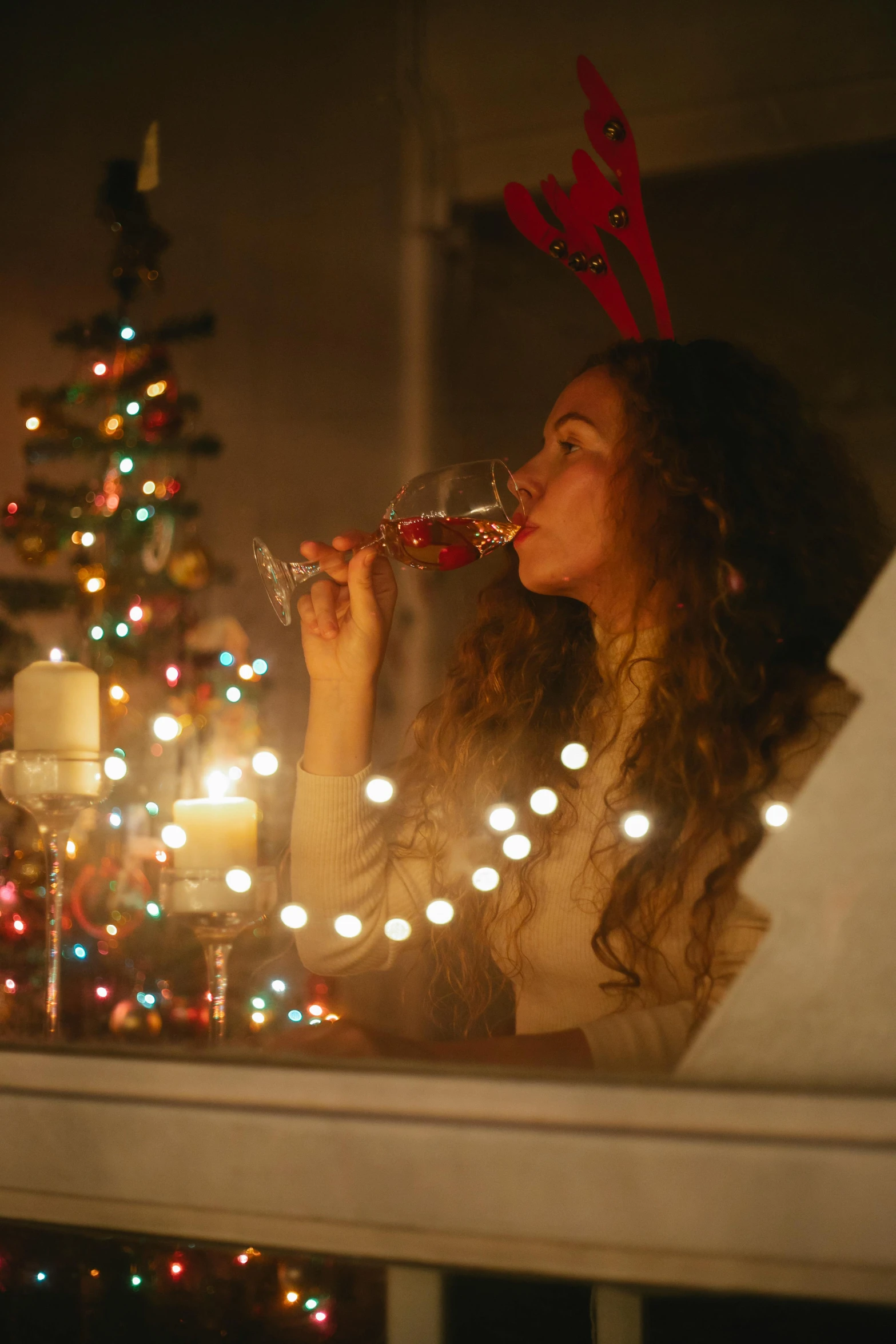 a woman drinking a glass of wine in front of a christmas tree, pexels, multiple stories, gif, light show, candy decorations