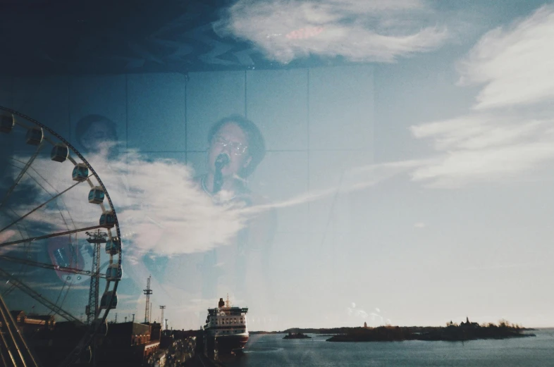 a ferris wheel sitting next to a body of water, by Anato Finnstark, pexels contest winner, surrealism, double exposure portrait, helsinki, vhs video effect, outside large window of ship