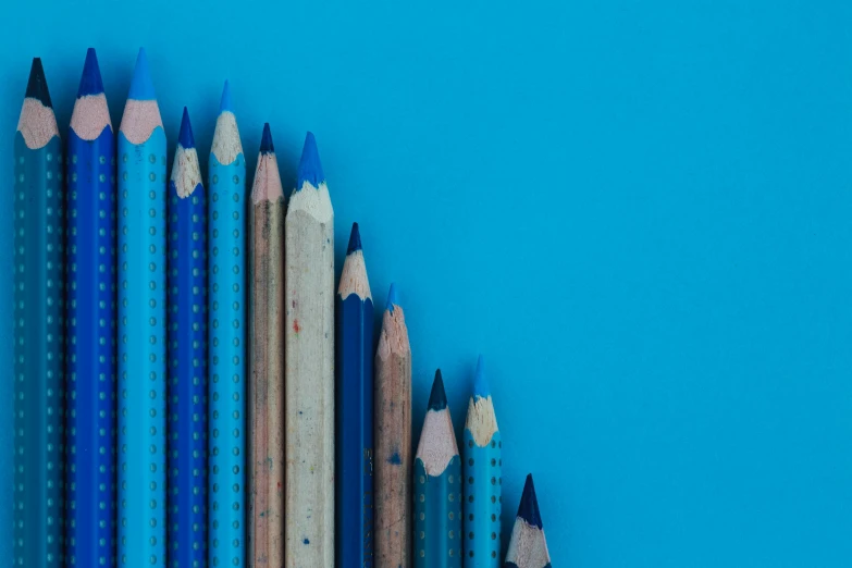 a group of colored pencils sitting next to each other, a minimalist painting, by Adam Marczyński, trending on unsplash, academic art, blue monochromatic, blue backdrop, highly intricate, 15081959 21121991 01012000 4k