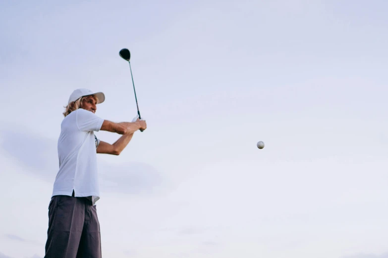 a man swinging a golf club at a ball, unsplash, uniform off - white sky, avatar image, half image, lachlan bailey