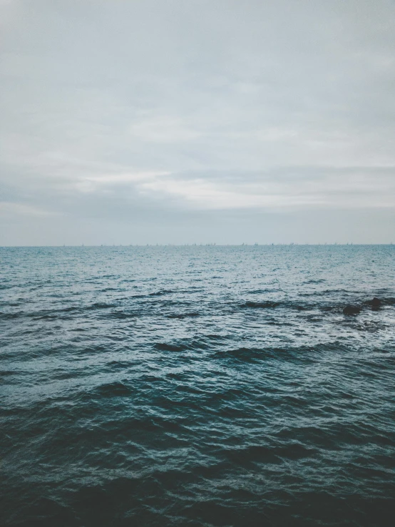 a large body of water under a cloudy sky, a picture, unsplash, happening, analogue photo low quality, the sea of sadness, multiple stories, subreddit / r / whale