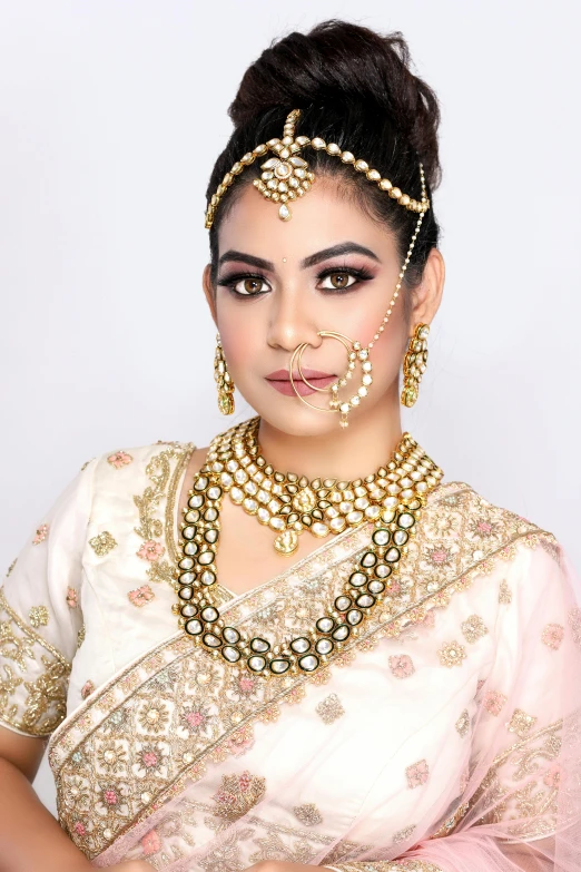 a woman in a white sari posing for a picture, inspired by Saurabh Jethani, featured on instagram, with professional makeup, multiple golden necklaces, on clear background, thumbnail