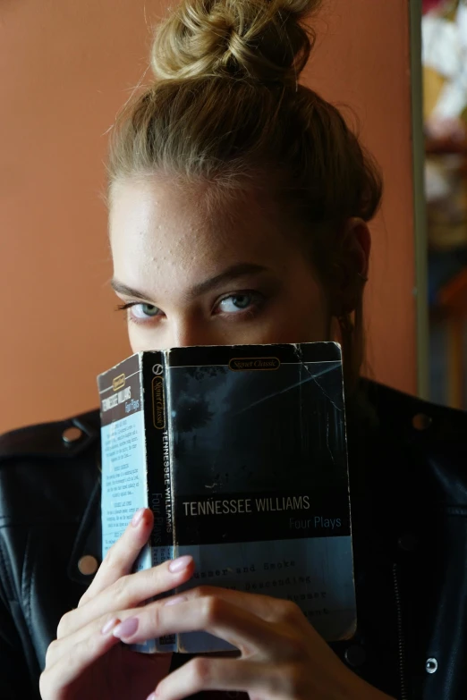 a woman holding a book in front of her face, an album cover, by Ben Thompson, yvonne strahovski, an epic non - binary model, instagram picture, tn