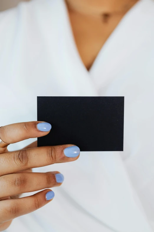 a woman holding a black business card in her hand, by Julia Pishtar, unsplash, private press, panel of black, 100lb cardstock, blue-black, blank