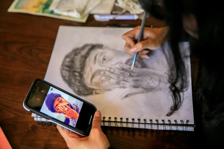 a person taking a picture of a drawing on a cell phone, a drawing, pexels contest winner, process art, portrait of danny trejo, drawing pictures on a notebook, student, trending on artstion