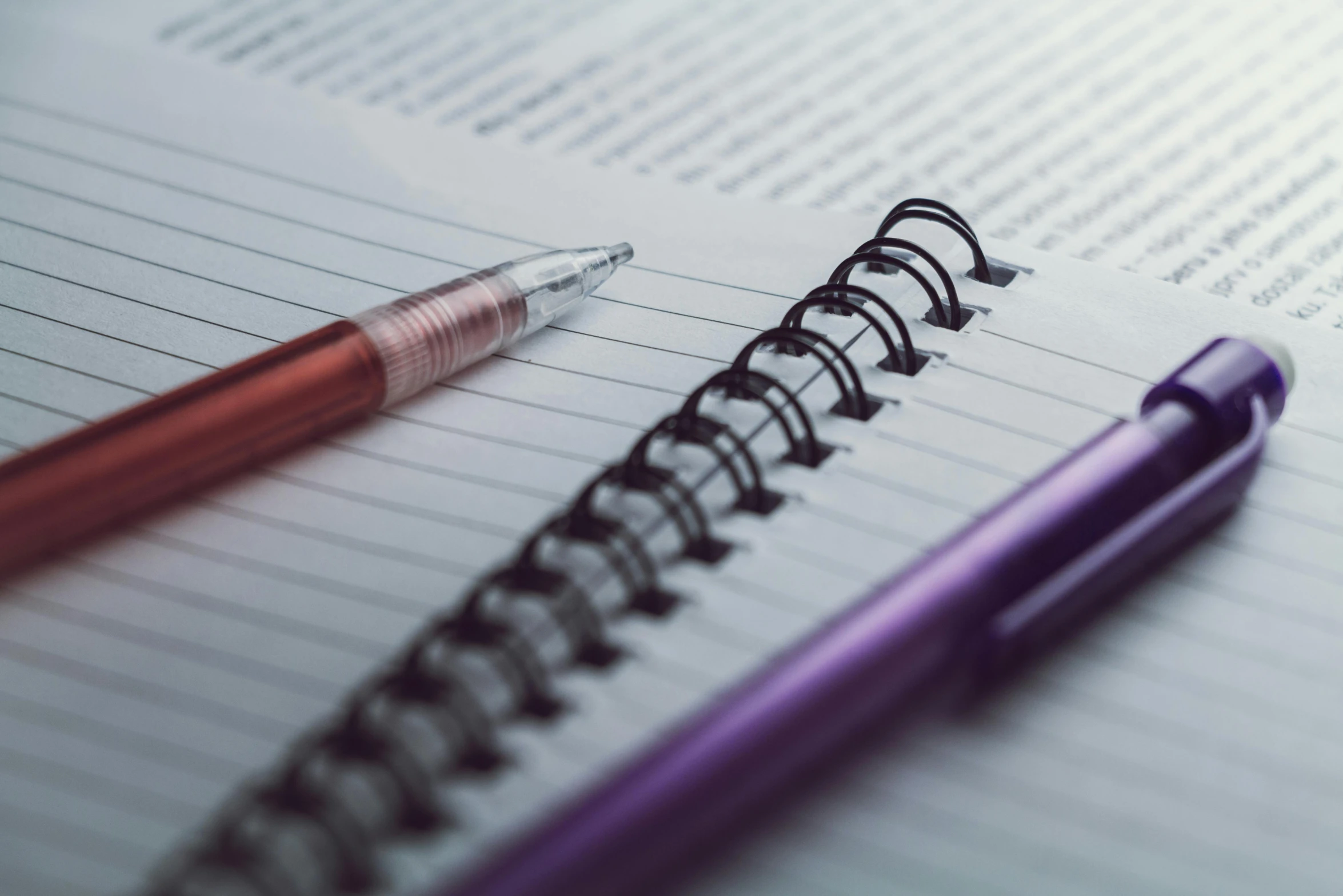 a pen and a spiral notebook on a table, pexels contest winner, purple and red, detailed screenshot, student, close-up shoot