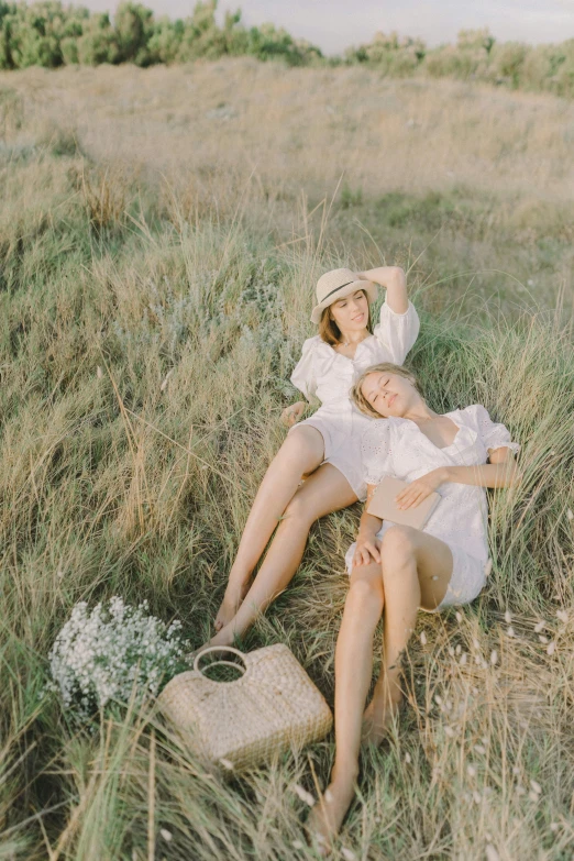 a couple of women sitting on top of a grass covered field, by Tan Ting-pho, unsplash, conceptual art, light cream and white colors, photoshoot for skincare brand, instagram post, cottagecore