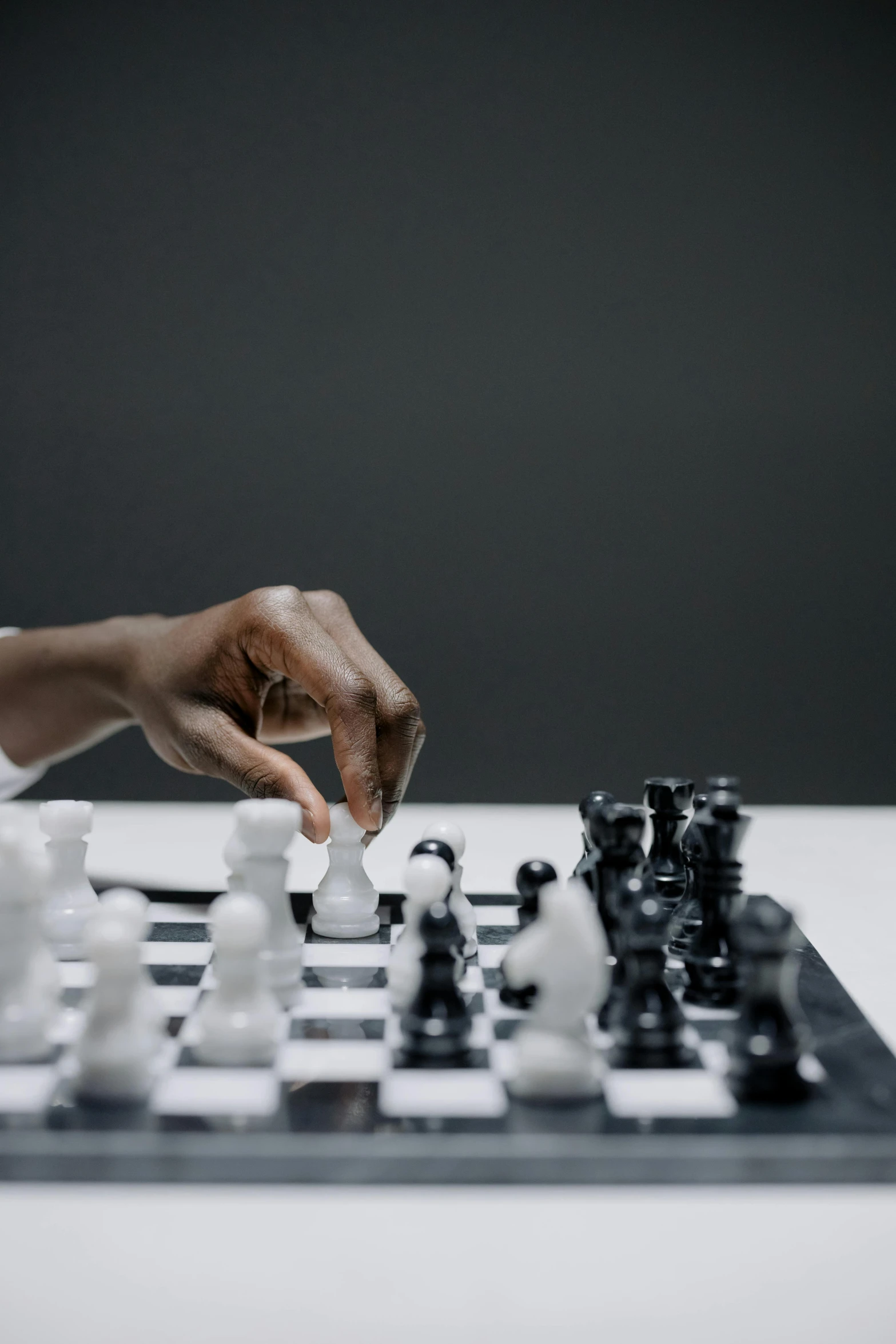 a person playing a game of chess on a table, white and black, thumbnail, black man, taken with sony alpha 9