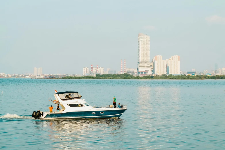 a boat in a body of water with a city in the background, by Oka Yasutomo, conde nast traveler photo, gulf, high quality upload, full body image