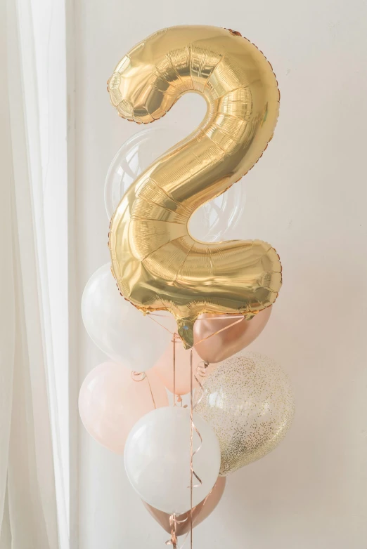 a bunch of balloons in the shape of a number 2, by Hirosada II, trending on unsplash, art nouveau, subtle gold accents, duo tone, toddler, pastel'