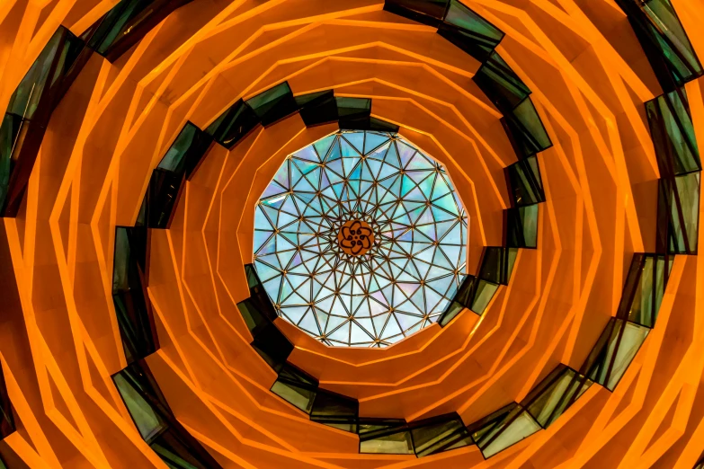 a picture of the inside of a building, an album cover, inspired by Buckminster Fuller, pexels contest winner, orange halo, kaleidoscope, spiral, faceted