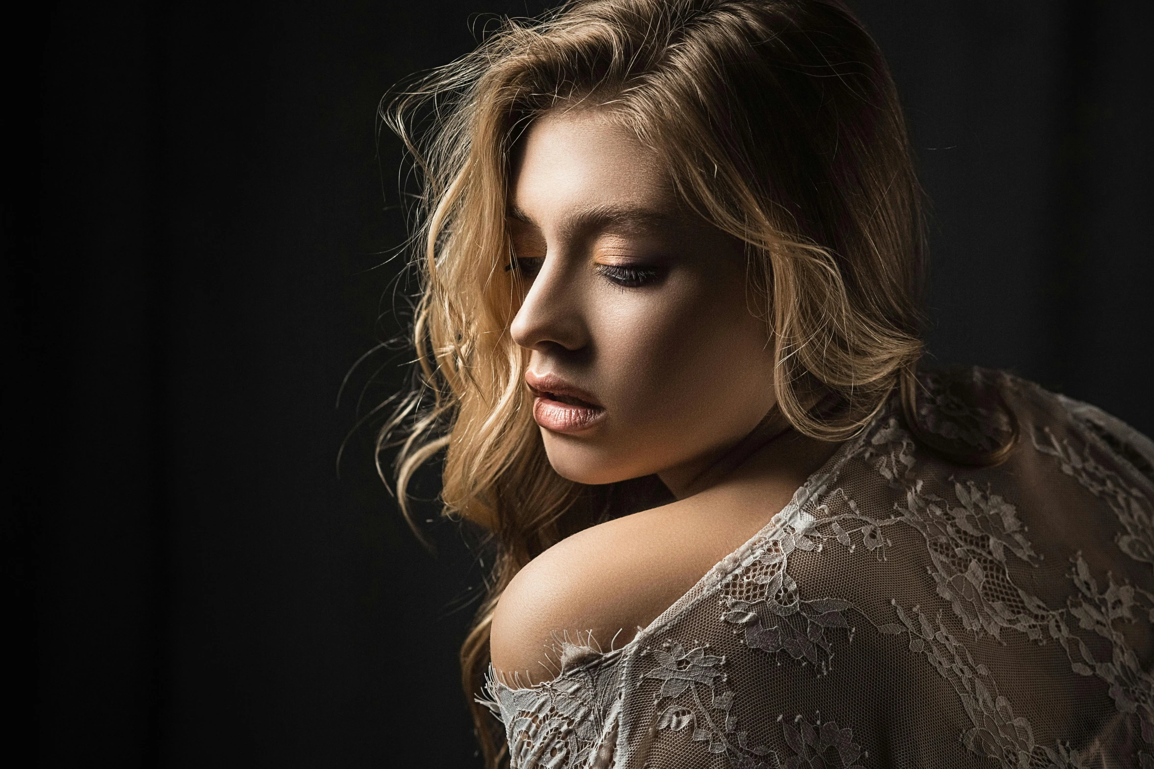 a woman posing for a picture in front of a black background, a character portrait, inspired by Elsa Bleda, trending on cgsociety, side portrait of imogen poots, flowing backlit hair, on grey background, close - up studio photo