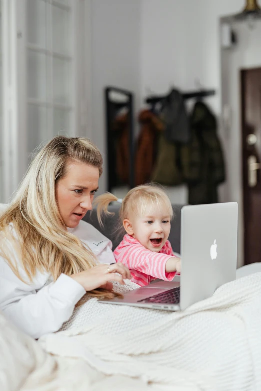 a woman sitting on a bed with a baby and a laptop, pexels contest winner, happening, close up to the screen, annoyed, avatar image, super high resolution