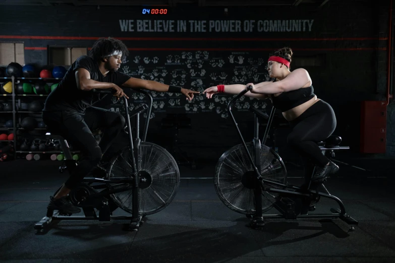 two women riding stationary bikes in a gym, a portrait, featured on reddit, realism, black widow, background image, advertising photo, plus-sized