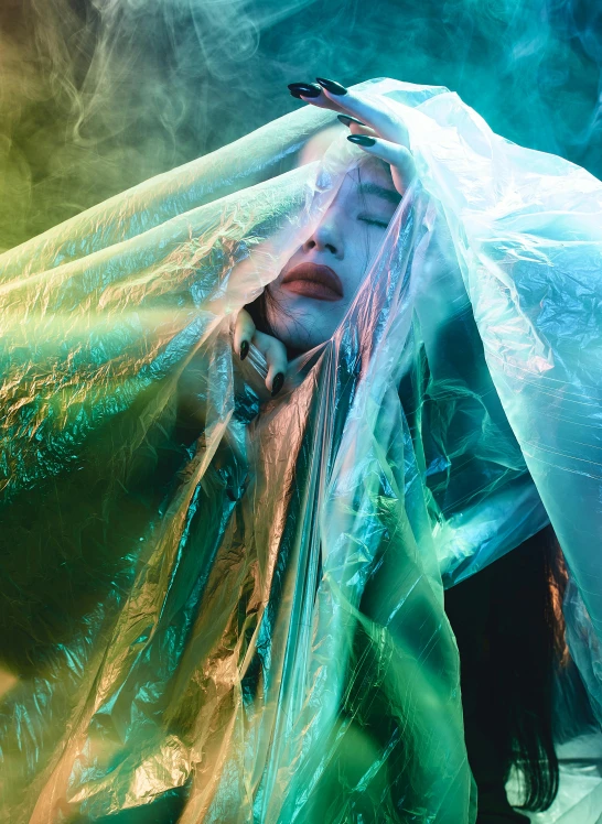 a woman covered in plastic standing on a stage, inspired by Ren Hang, unsplash, luminescent fabrics, grimes, promotional image, veiled