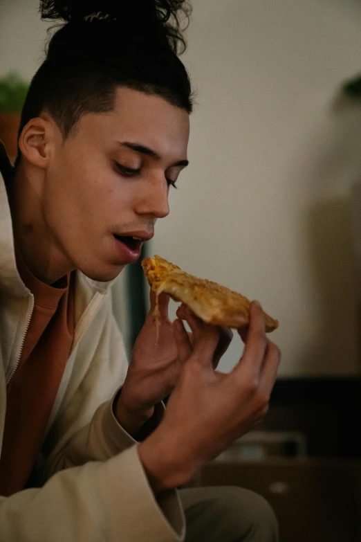 a man sitting on a couch eating a slice of pizza, inspired by Carlos Berlanga, trending on pexels, visual art, non binary model, profile image, still from a music video, chicken