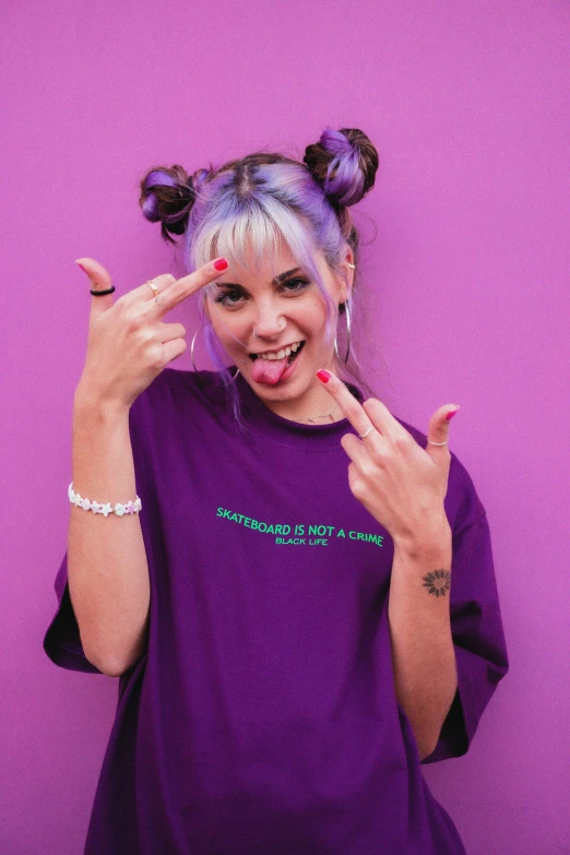 a woman in a purple shirt making a peace sign, an album cover, trending on pexels, antipodeans, melanie martinez, lazertag, colourful clothing, graphic tees