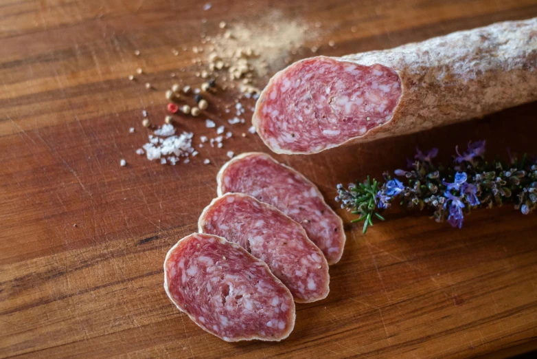 sliced salami sitting on top of a wooden cutting board, a portrait, pexels, fan favorite, meat and lichens, whole-length, confetti