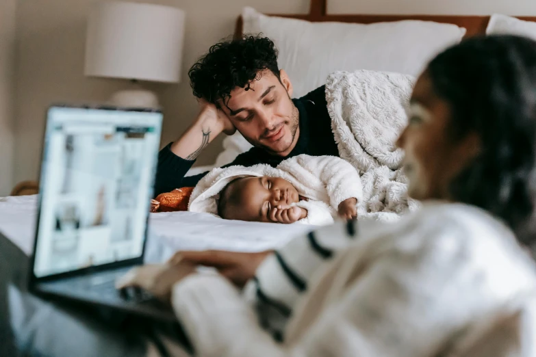 a man and woman laying in bed with a baby, pexels contest winner, happening, in front of a computer, charli bowater and artgeem, profile image, comforting