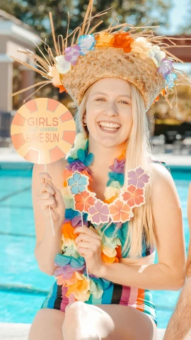 a man and a woman sitting next to a swimming pool, a colorized photo, unsplash, the girl made out of flowers, woman holding sign, orange and turquoise and purple, beach party